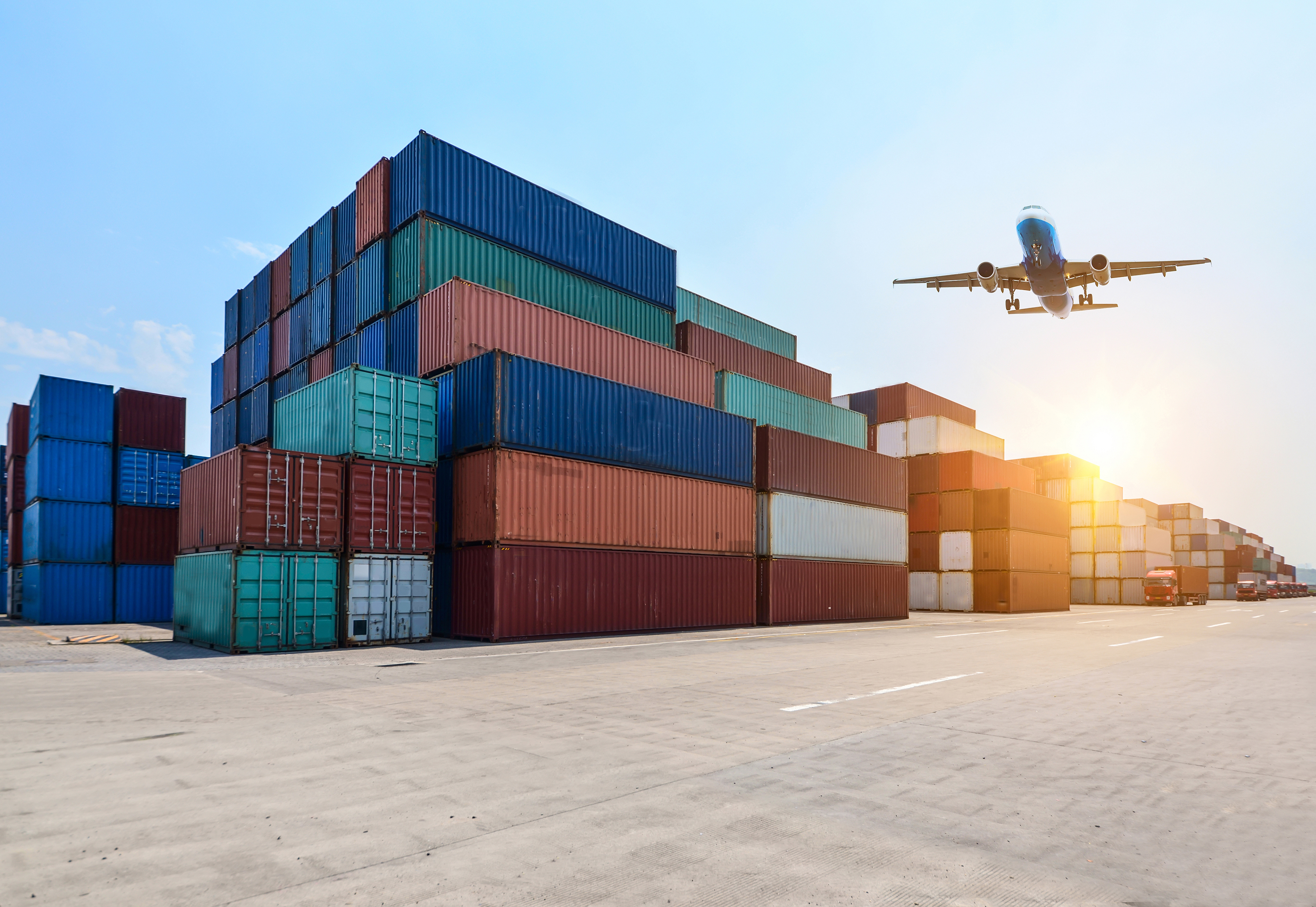 Aeroplane flying over shipping containers
